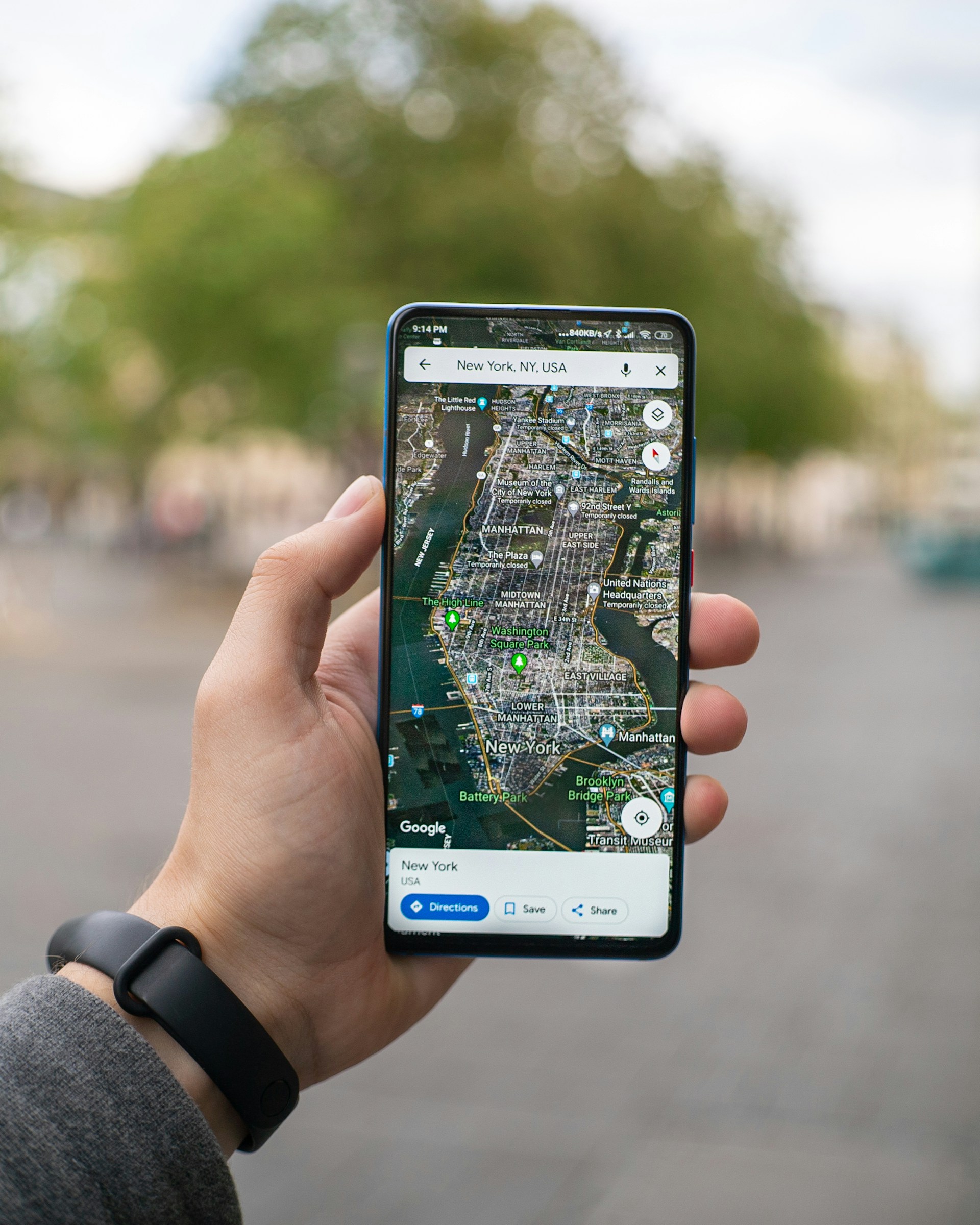 Imagem de homem segurando um celular com o mapa aberto.